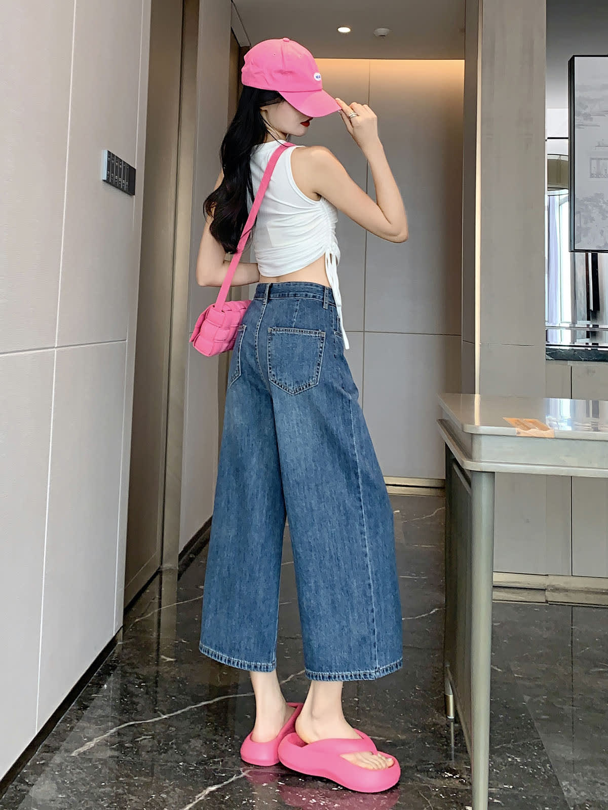 YEEYEEWang 빈티지 블루 와이드레그 진, 아시안핏, 전신 뒷모습 서서, 뒤 패치 포켓, 핑크 캡과 크로스백.