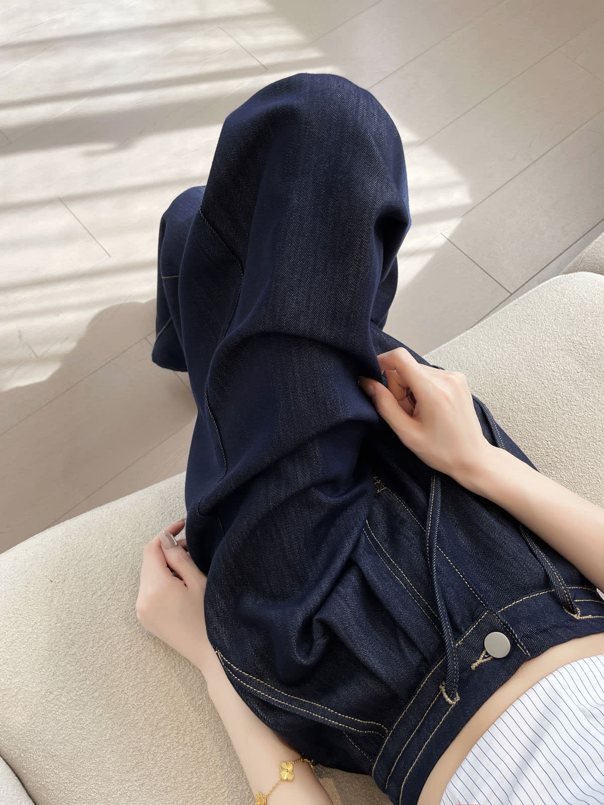 YEEYEEWang 데님 블루 와이드레그 진, 아시안핏, 두 손으로 와이드 밑단을 들어 보인 클로즈업, 부드러운 드레이프와 스티치.