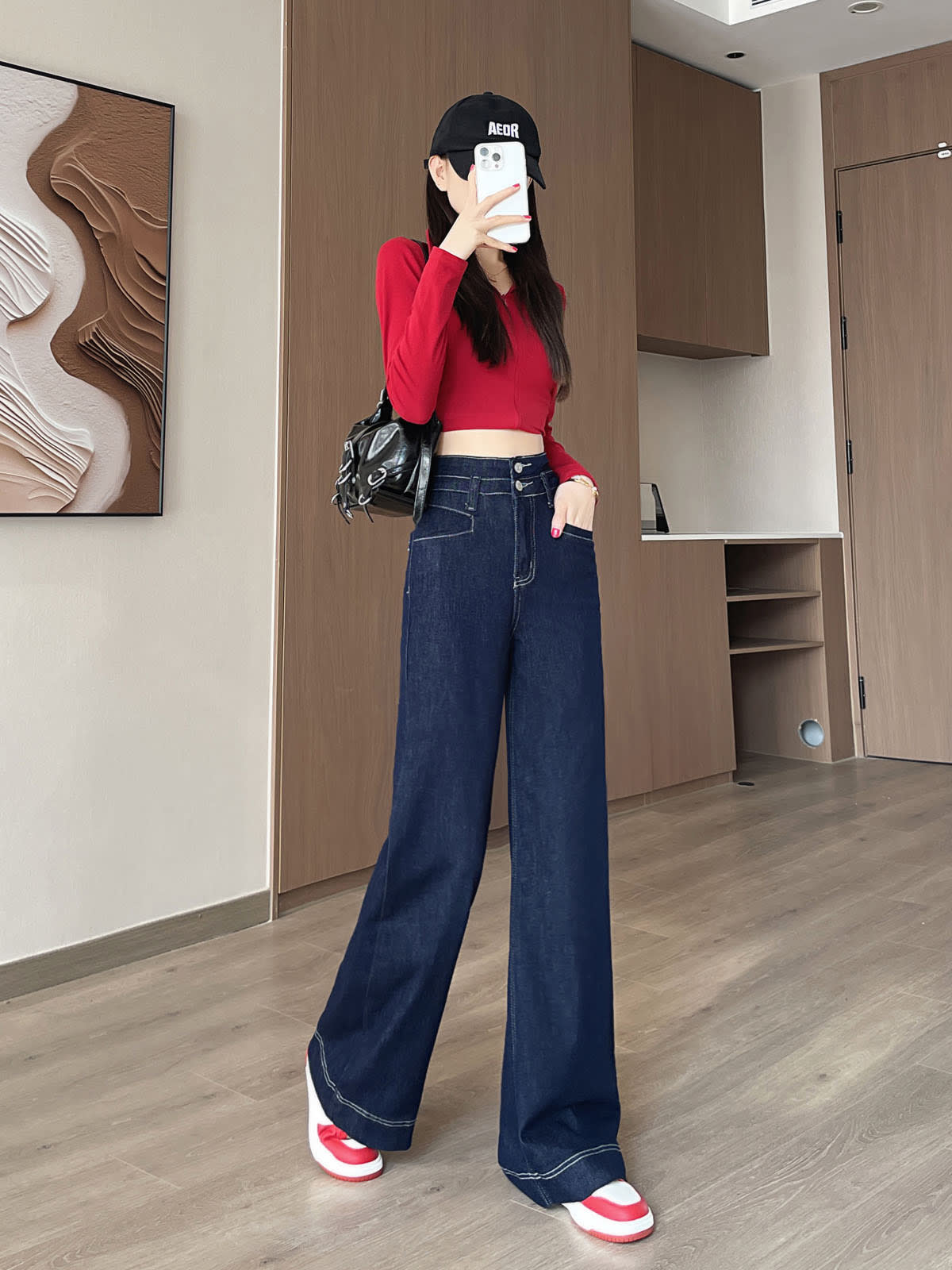 YEEYEEWang 데님 블루 와이드레그 진, 아시안핏, 전신 정면 포즈, 얼굴 앞에 폰, 한 손 주머니에, 블랙 백.