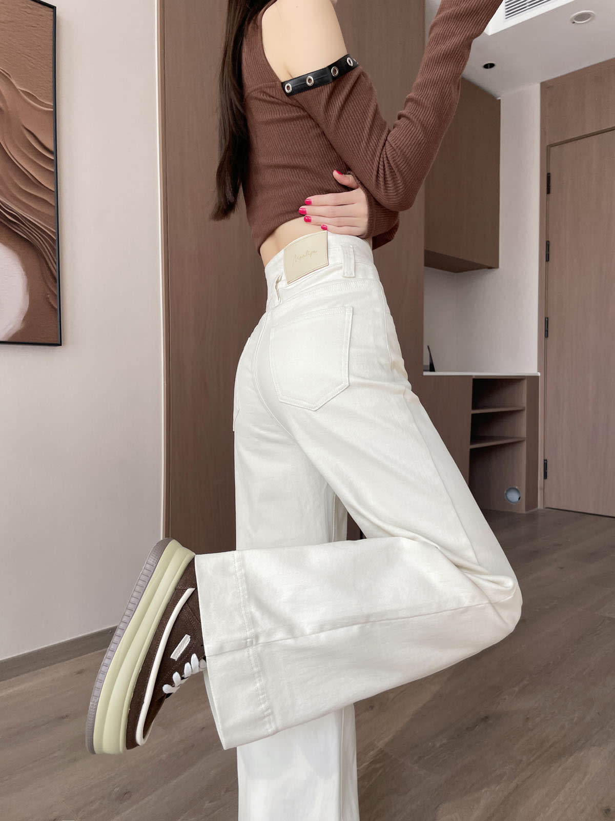 YEEYEEWang 아이보리 와이드레그 진, 아시안핏, 한쪽 다리 뒤로 든 포즈, 뒷주머니와 가죽 패치, 브라운 스니커즈.