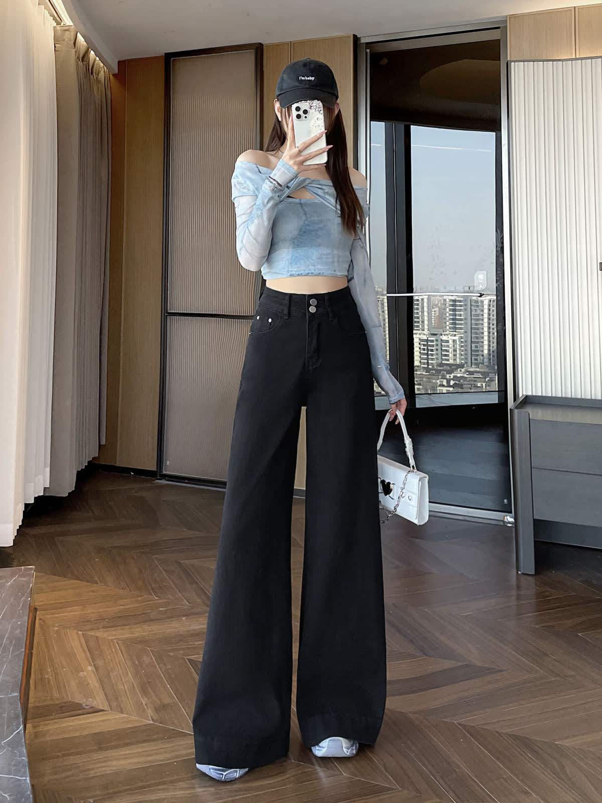 YEEYEEWang 솔리드 블랙 와이드레그 진, 아시안핏, 전신 정면에서 폰을 얼굴 앞에 들고 흰 가방, 오프숄더 탑.