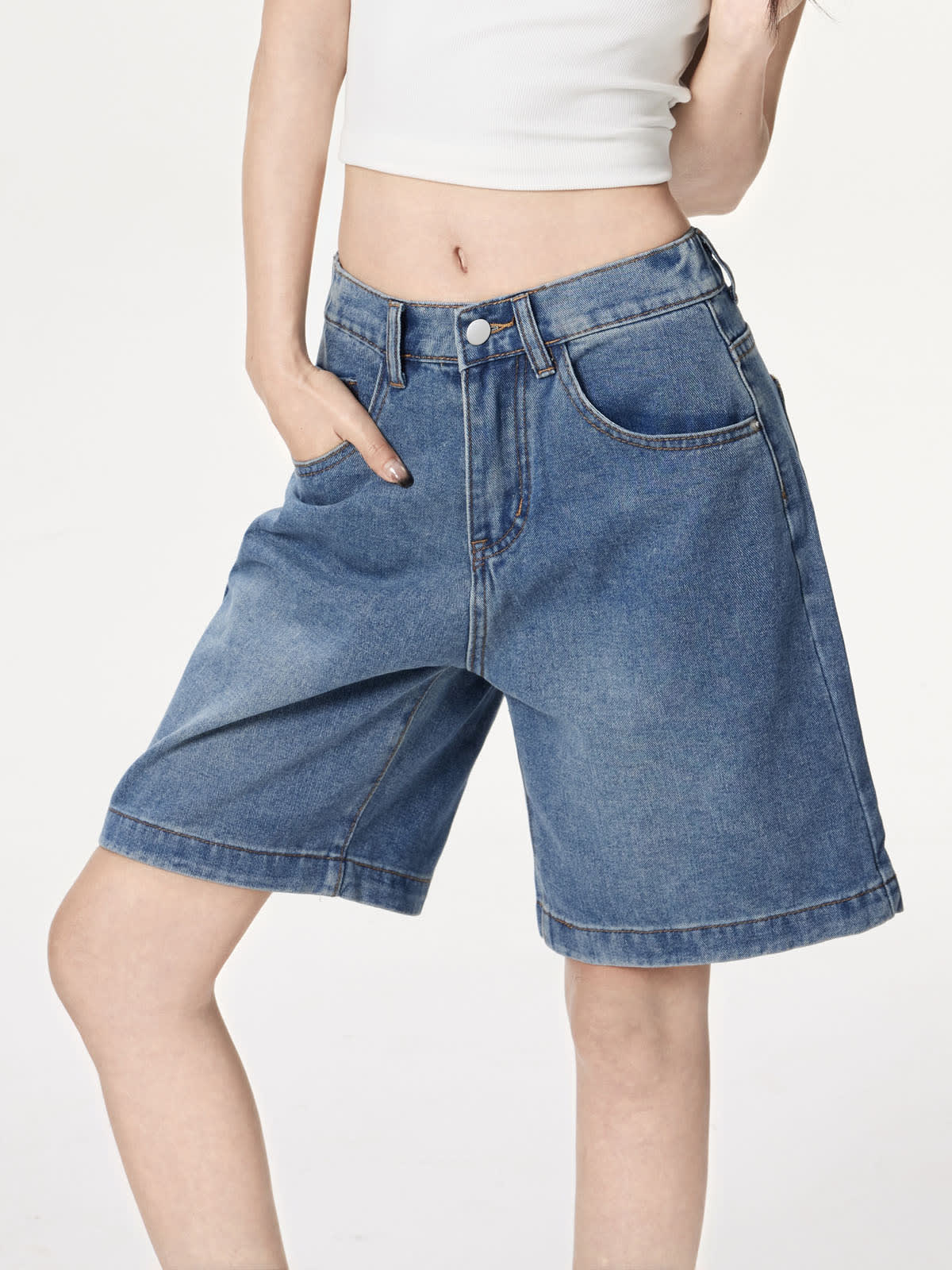 YEEYEEWang 블루 데님 버뮤다 쇼츠, 아시안핏, 허리 아래 선 자세로 앞주머니에 손을 넣은 변형 썸네일.