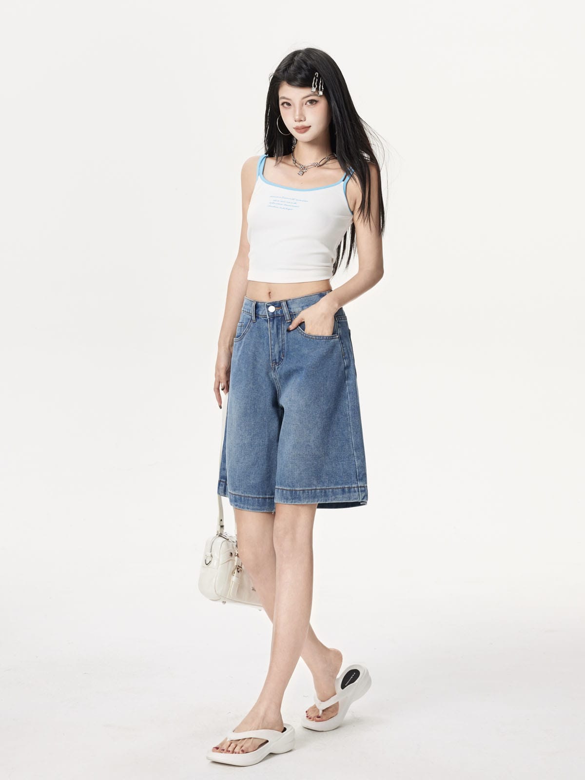 YEEYEEWang 블루 데님 버뮤다 쇼츠, 아시안핏, 전신 3/4 선 자세로 화이트 백을 옆에 들고 한 손은 앞주머니에.