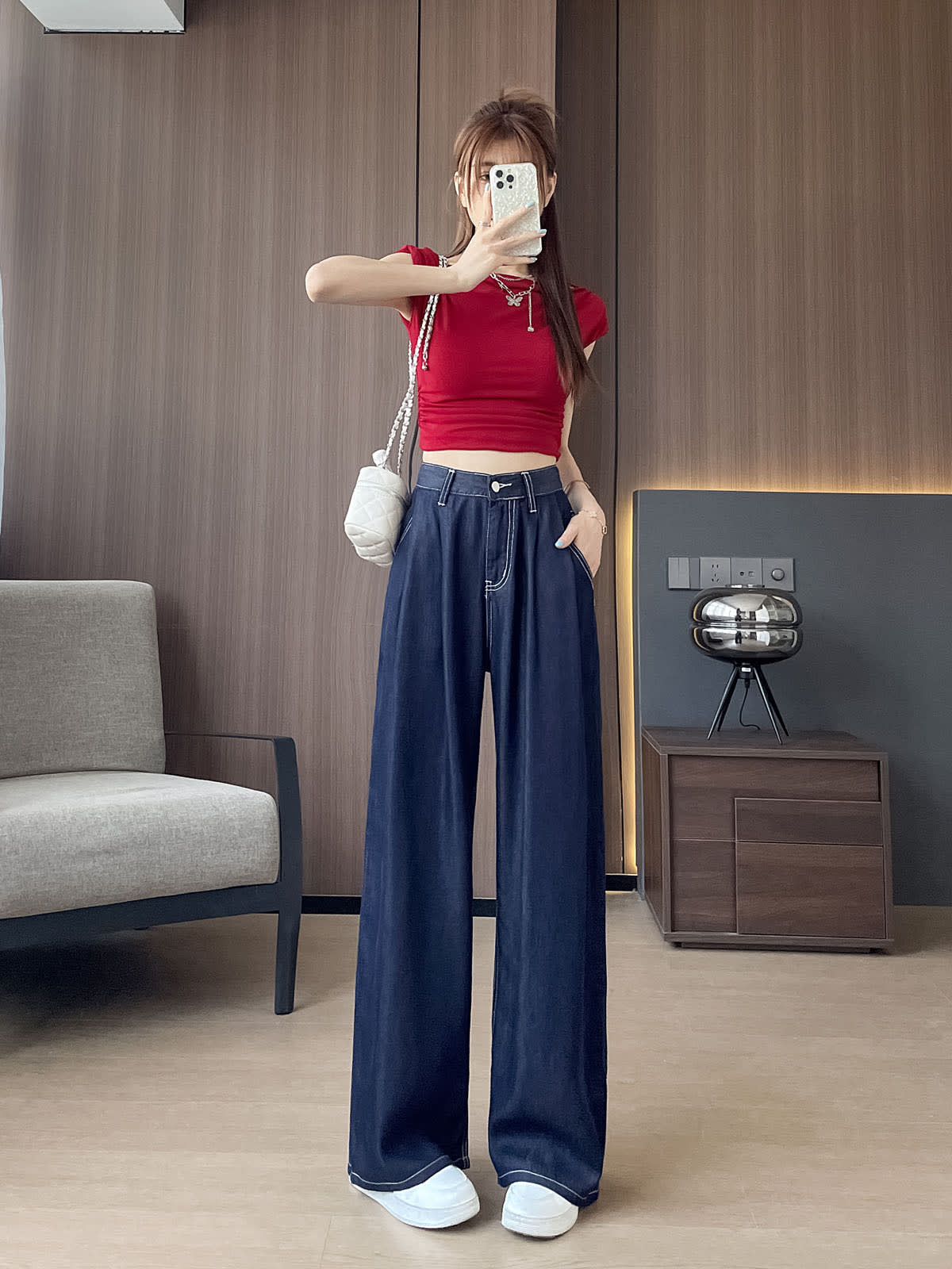 YEEYEEWang 데님 블루 와이드 레그 진, 아시안핏, 전신 정면 포즈, 휴대폰을 얼굴 앞에 들고 한 손은 주머니에, 화이트 퀼팅 체인백 착용.