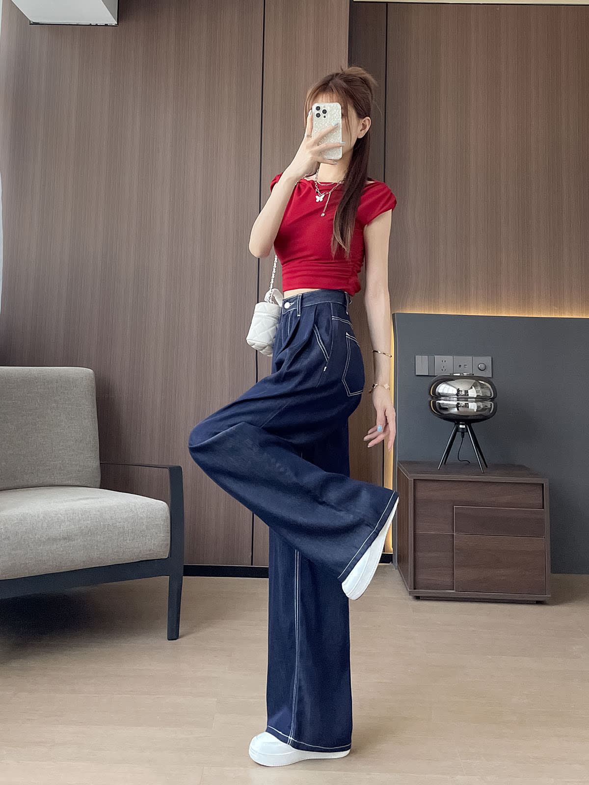 YEEYEEWang 데님 블루 와이드 레그 진, 아시안핏, 전신 측면 한 다리 킥 포즈, 휴대폰을 얼굴 앞에, 레드 크롭탑과 화이트 체인백.